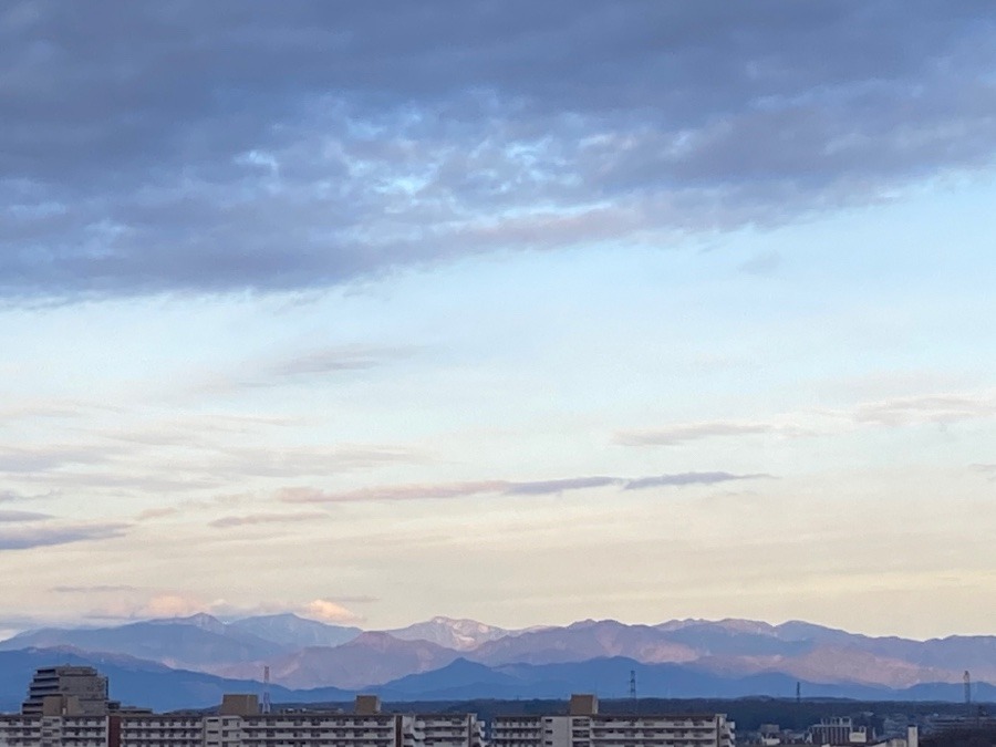 人のたくさん住む街　マンションと奥に連なる山々のシルエットが美しい