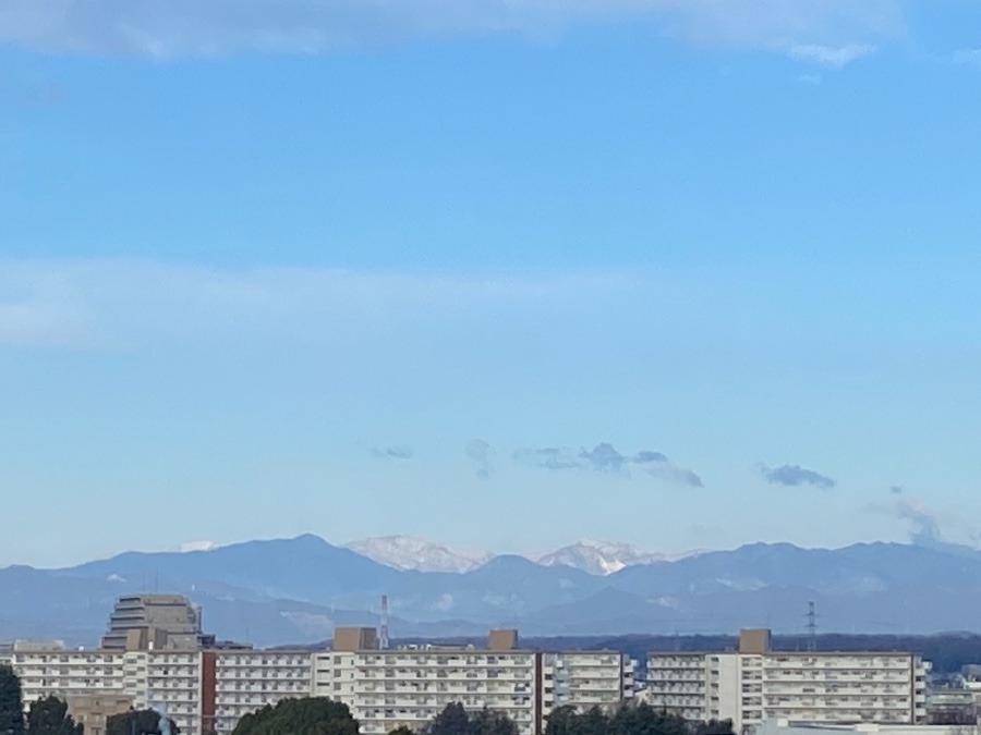 ビル群　山々　その奥に雪の積もった大きな山々