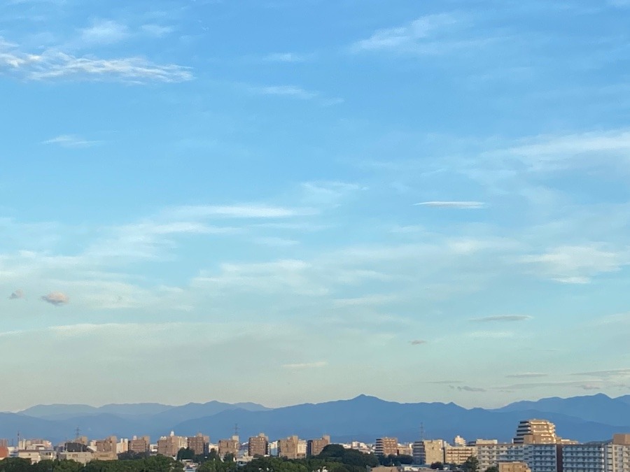 夏のビル群と夏の山々